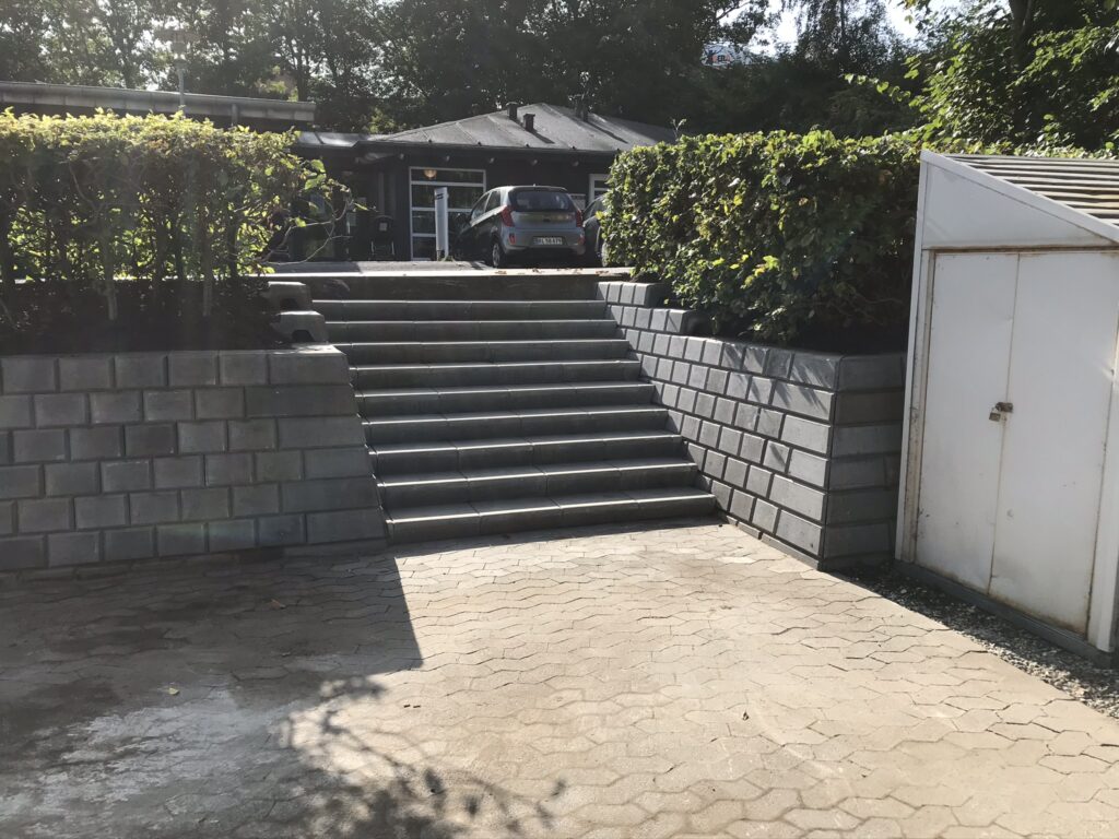 Udendørs trappe til hus med parkeret bil foran