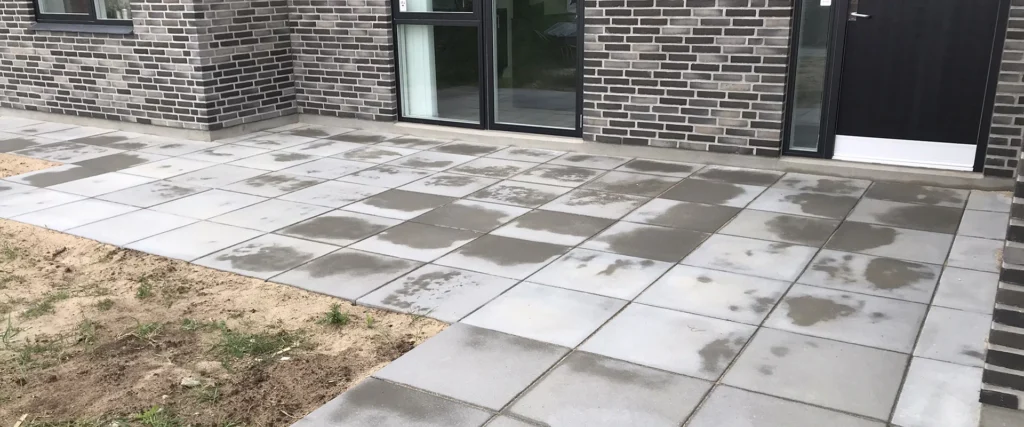 Nyudlagt flisebelægning foran murstenshus