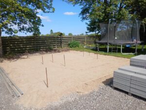 Forberedt sandgrund til ny fliseterrasse i haven